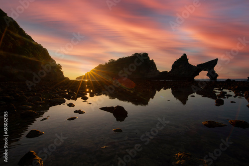 Beautiful sunrise scenery of unique rock island at atuh beach nusa penida, bali photo