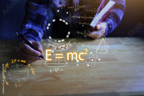 Student hands writing a notebook with a pen and Albert's einstein general relativity equation. physics equations floated in light and graphics. the equation is emc2 or em c square student.