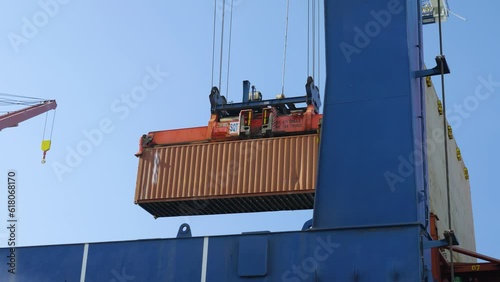 4K footage of port crane lifting cargo container. Loading and unloading of freight at dock stock video.  