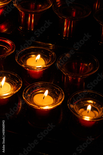 Burning candles in red candlesticks in the dark