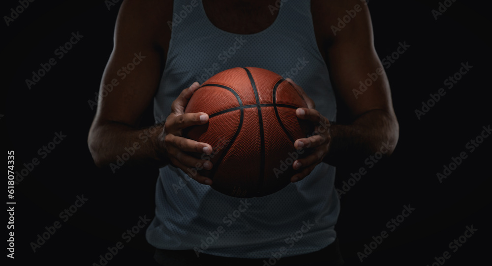 Close up of basketball ball in athlete hands, isolated on black background with copy space Close up of basketball ball in athlete hands, isolated on black background with copy space