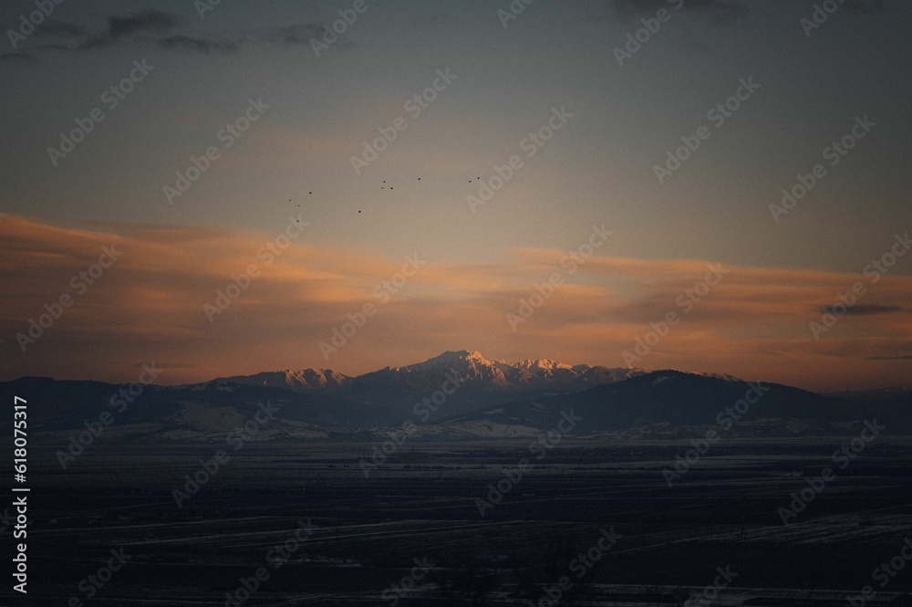 Stunning landscape of snow covered mountain range during sunset