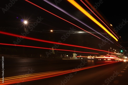 Long exposure shot of the light trails of transportation along the road in the city at night