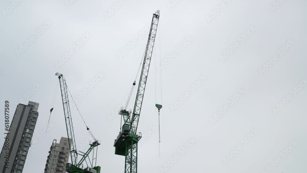 Crane carries heavy load swinging large arm through Hong kong city Crane carries heavy load swinging large arm through Hong kong city
