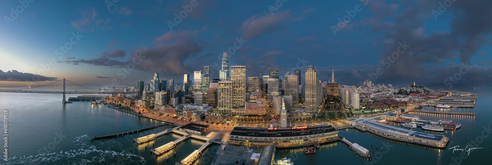 Fototapeta premium a city is seen in the water at night, with boats and skyscrapers in