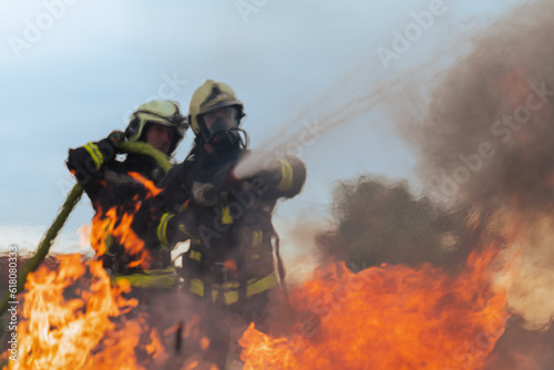 Firefighters fight the fire flame to control fire not to spreading out. Firefighter industrial and public safety concept. Traffic or car accident rescue and help action. 