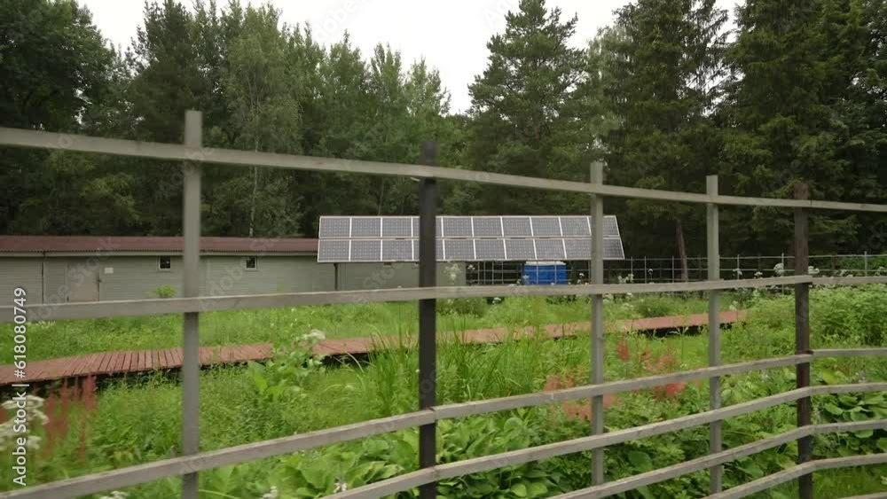 Solar panels are installed in the garden behind the fence. Installations for solar energy. Dolly camera Solar panels are installed in the garden behind the fence. Installations for solar energy. Dolly camera
