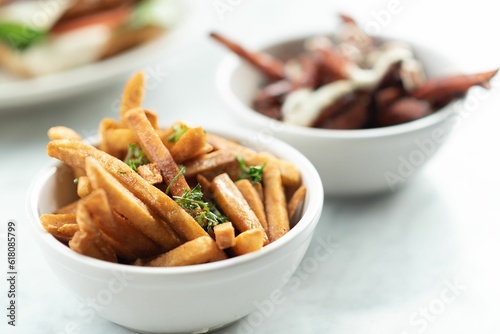 Closeup shot of fries with seasonings in a white bowl on a table