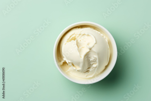 Top view of delicious vanilla milk ice cream in a round white vase isolated on a light pastel green background. Copy space for text. Generative AI photo.