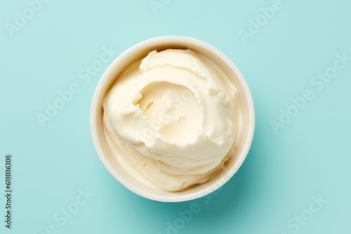 Above view of delicious vanilla milk ice cream in a round white vase isolated on a light pastel blue background. Copy space for text. Generative AI photo.