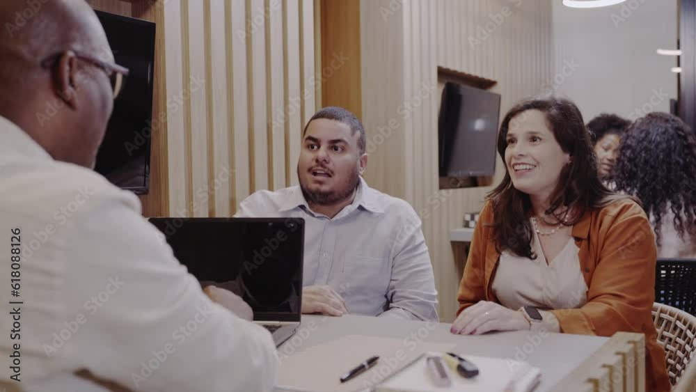 casal Brasileiro conversando com o gerente do banco explicando que precisam do fianciamento imobiliario porque ela esta gravida e precisam ampliar sua casa no Brasil