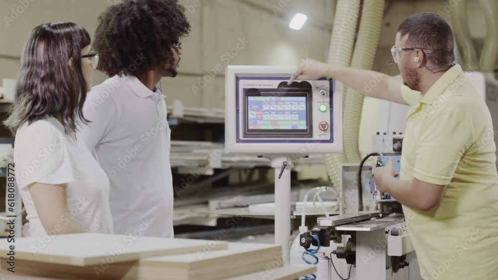 professor de um curso de tecnologia mostrando para os alunos como programar uma máquina industrial durante aula prática em uma fábrica no Brasil professor de um curso de tecnologia mostrando para os alunos como programar uma máquina industrial durante aula prática em uma fábrica no Brasil