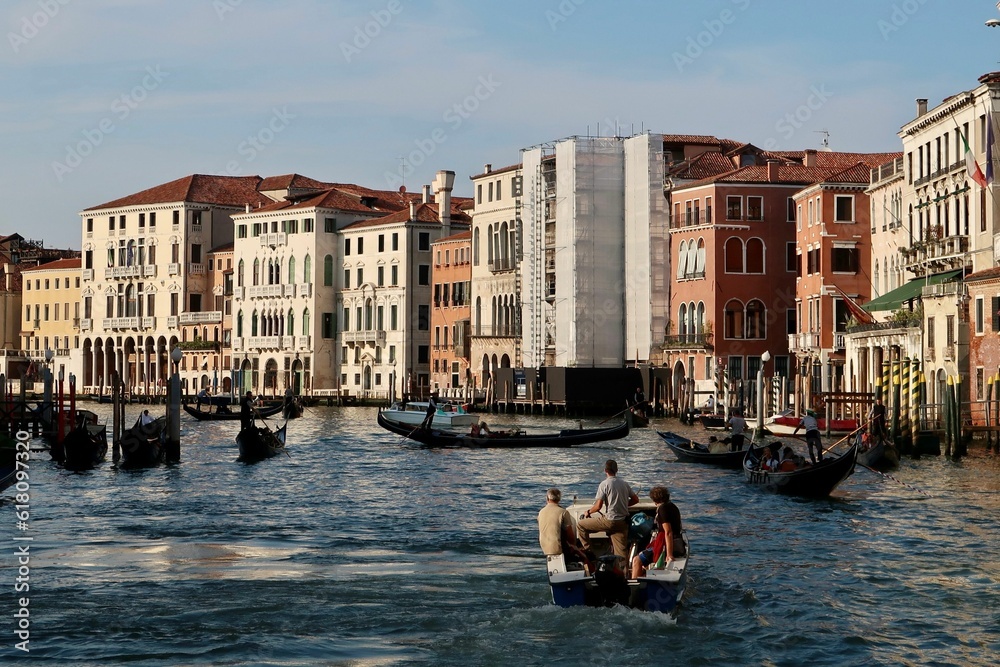 Group of people in small vessels navigating through a canal in Venice