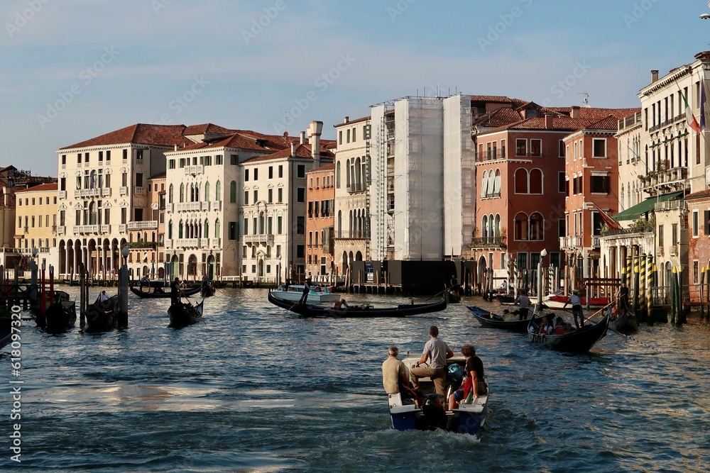 Obraz premium Group of people in small vessels navigating through a canal in Venice
