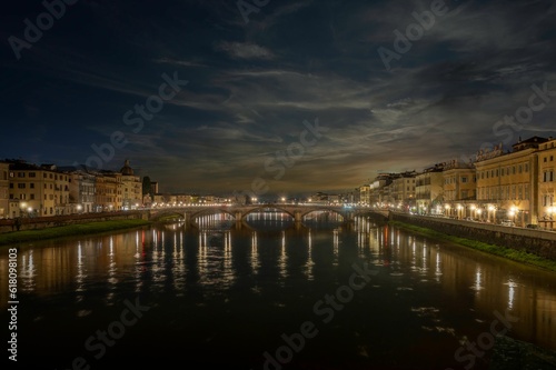Tranquil scene featuring a a bridge over the tranquil river in Florence  Italy at night