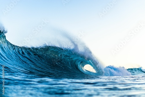 Fototapeta Naklejka Na Ścianę i Meble -  Large, powerful wave crashing against the shoreline of a beach