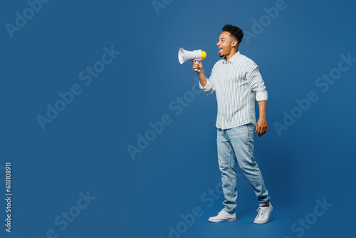 Full body young man of African American ethnicity he wear casual clothes shirt hold in hand megaphone scream announces discounts sale Hurry up isolated on plain dark royal navy blue background studio.