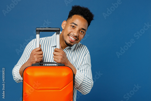 Traveler happy man wear casual clothes shirt hold suitcase isolated on dark royal navy blue background studio. Tourist travel abroad in free spare time rest getaway. Air flight trip journey concept. #618108923