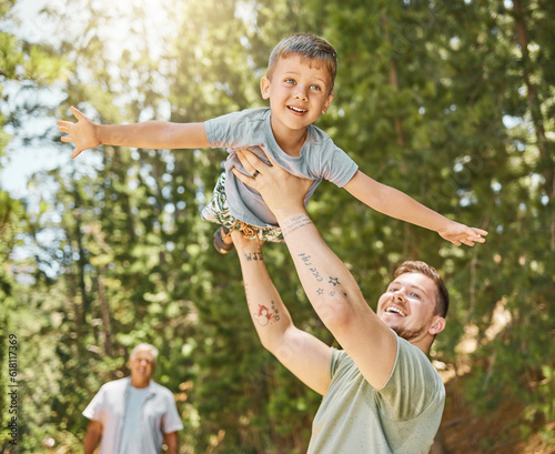 Hiking, love and a boy flying with his father outdoor in nature while camping in the forest or woods. Family, fun and a young child son playing with his happy dad or parent in the sunny wilderness