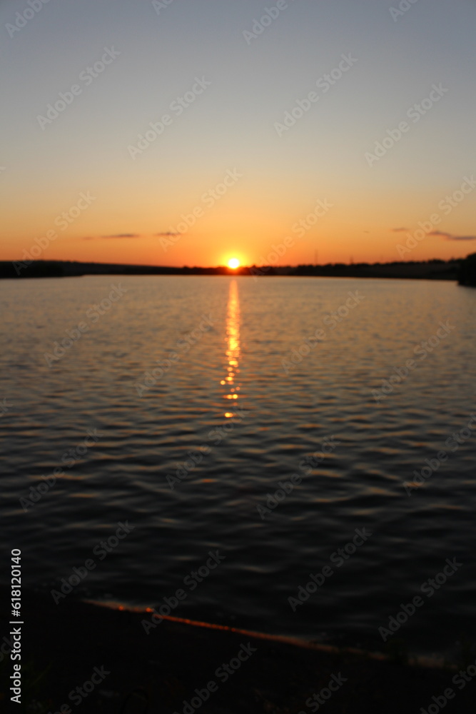 A body of water with a boat in it and the sun setting