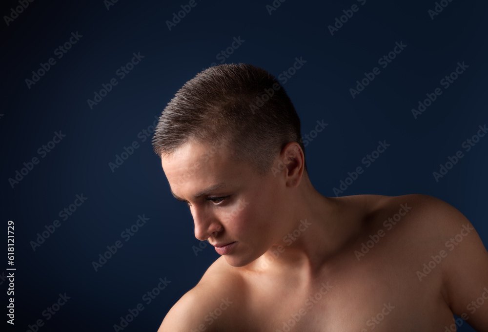 portrait of young woman with short hair and bare shoulder on blue background portrait of young woman with short hair and bare shoulder on blue background