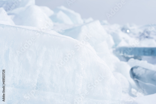Ice hummocks on Baikal Lake. Snow covered ice floe in sunlight. Natural background with copy space.