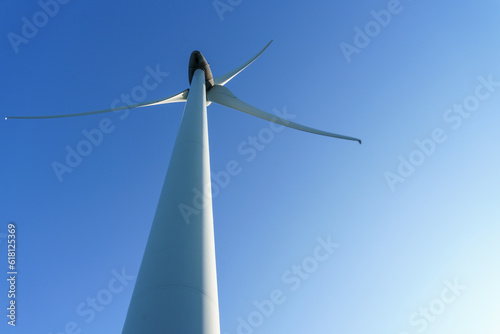 distant view of a single wind turbine against a clear blue sky