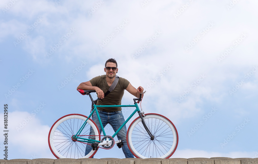 Fototapeta premium Urban man wearing sunglasses on a cloudscape