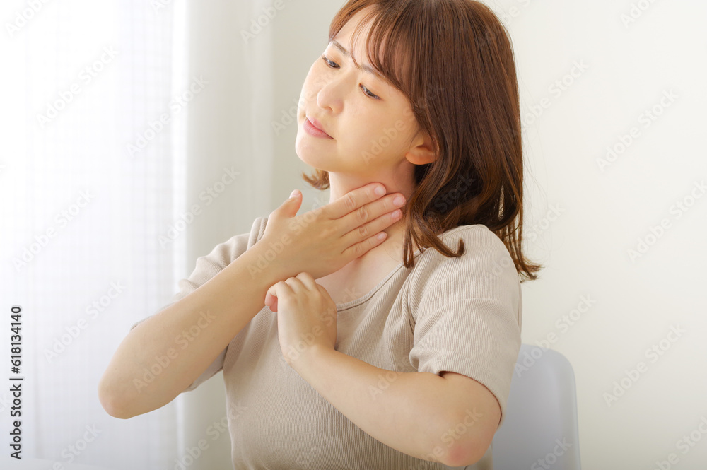 首のまわりが痛そうな若い女性 首のまわりが痛そうな若い女性