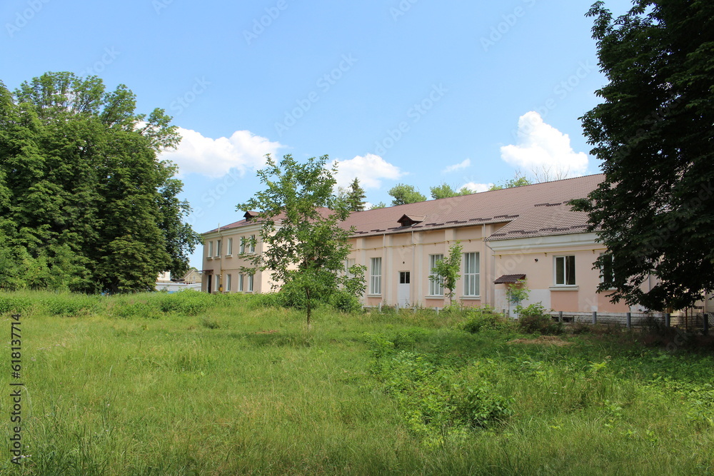 A house with a fence and trees in the front A house with a fence and trees in the front