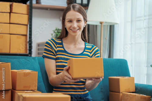 Startup small business entrepreneur SME or freelance woman using a laptop with box, Caucasian woman seller prepare parcel box of product for delivery to customer Online selling e-commerce SME concept