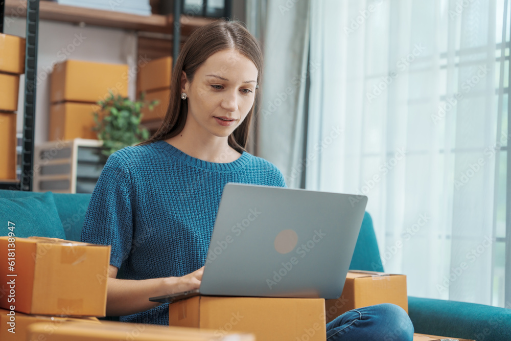 Startup small business entrepreneur SME or freelance woman using a laptop with box, Caucasian woman seller prepare parcel box of product for delivery to customer Online selling e-commerce SME concept Startup small business entrepreneur SME or freelance woman using a laptop with box, Caucasian woman seller prepare parcel box of product for delivery to customer Online selling e-commerce SME concept