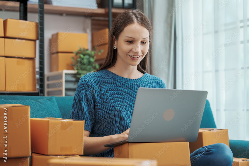 Startup small business entrepreneur SME or freelance woman using a laptop with box, Caucasian woman seller prepare parcel box of product for delivery to customer Online selling e-commerce SME concept Startup small business entrepreneur SME or freelance woman using a laptop with box, Caucasian woman seller prepare parcel box of product for delivery to customer Online selling e-commerce SME concept