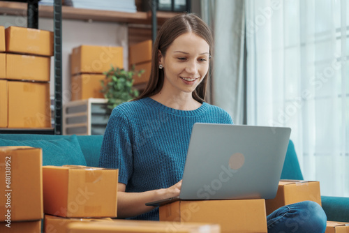 Startup small business entrepreneur SME or freelance woman using a laptop with box, Caucasian woman seller prepare parcel box of product for delivery to customer Online selling e-commerce SME concept © M+Isolation+Photo