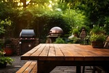 An empty dark wood table with space for promotional items against a backyard with a BBQ and grill.