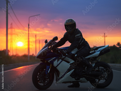 motorcyclist on a sports bike at sunset © pavelkant
