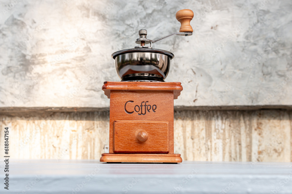 Manual coffee bean grinder on natural wooden background Manual coffee bean grinder on natural wooden background