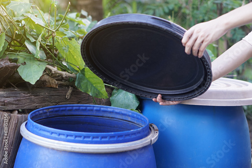 Closeup hand hold lid to cover water bucket to protect from mosquito to breed inside or other  insects or dust go into water. Concept, campaign to stop mosquitoes cycle to lay eggs in water container  photo