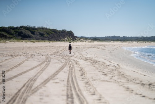 girl hiking on a sandy beach in springtime in australia