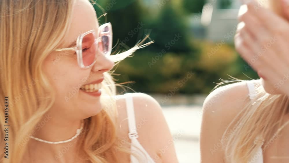 Two young beautiful blond smiling hipster women in trendy summer white t-shirt and jeans clothes. Carefree women posing in street. Positive models having fun in sunglasses. Cheerful and happy Two young beautiful blond smiling hipster women in trendy summer white t-shirt and jeans clothes. Carefree women posing in street. Positive models having fun in sunglasses. Cheerful and happy
