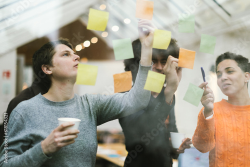 Photography teamwork, young entrepreneurs make up their mind by working with adhesive notes