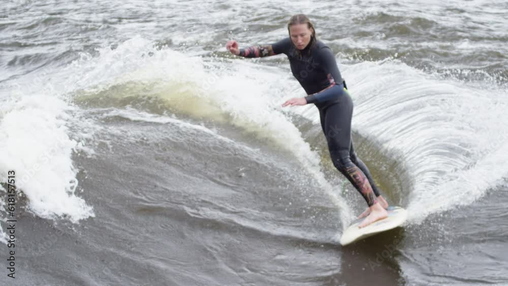 Woman athlete - Surfing on a river wave Woman athlete - Surfing on a river wave
