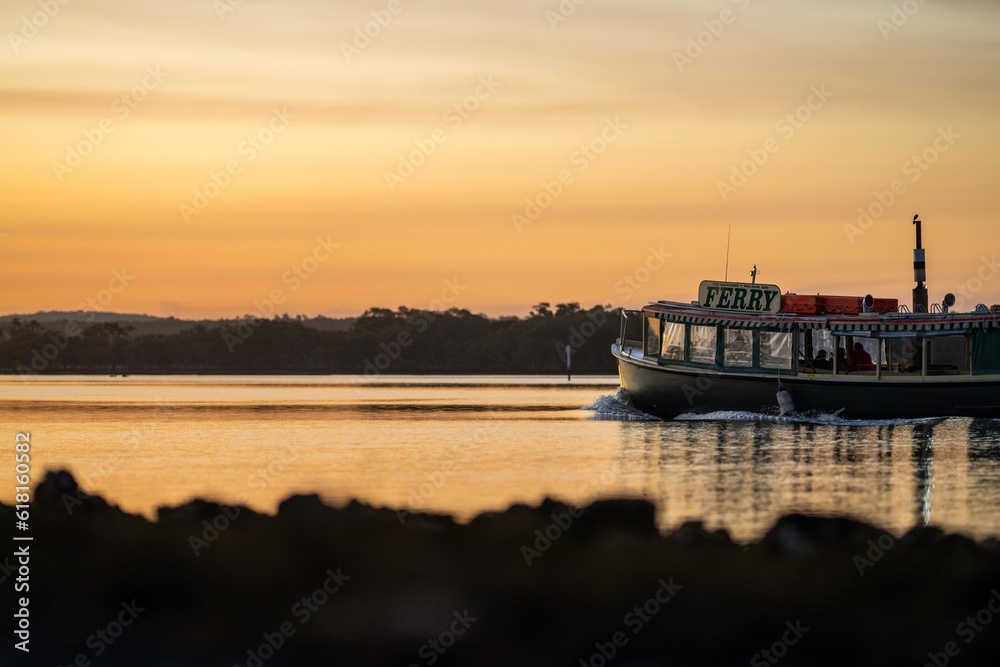 wooden ferry boat on a river crossing at sunset in australia
