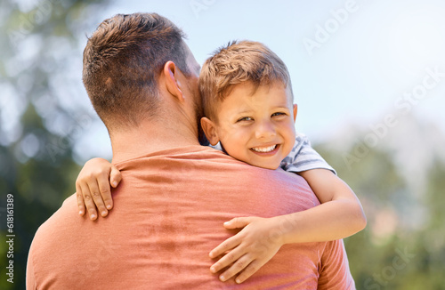 Portrait, father and son hug, outdoor and smile with quality time, bonding and loving together. Face, dad and male child with happiness, kid and parent embrace, park and care with joy and support