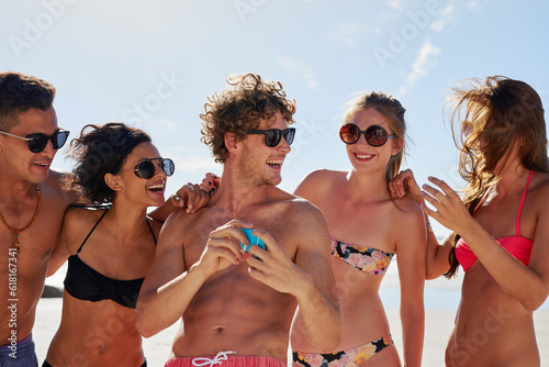 Social media, travel and friends on the beach with a phone to post a status update while on vacation together. Mobile, freedom and a group of young people outdoor in nature for summer holiday