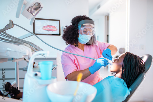 Young female dentist working on a little girls teeth in her dental office