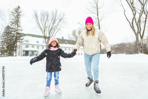 little girl skater in a winter park having fun with her daughter