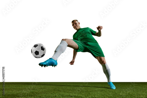 Bottom view. Competitive man, football player in green uniform kicking ball with leg against white background. Concept of professional sport, action, lifestyle, competition, hobby, training, ad © master1305