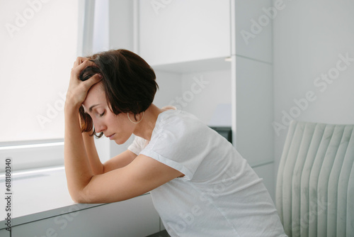Tired, frustrated, exhausted, stressed woman sitting at desk . Female sleeping at Daylight work. Girl in White tshirt