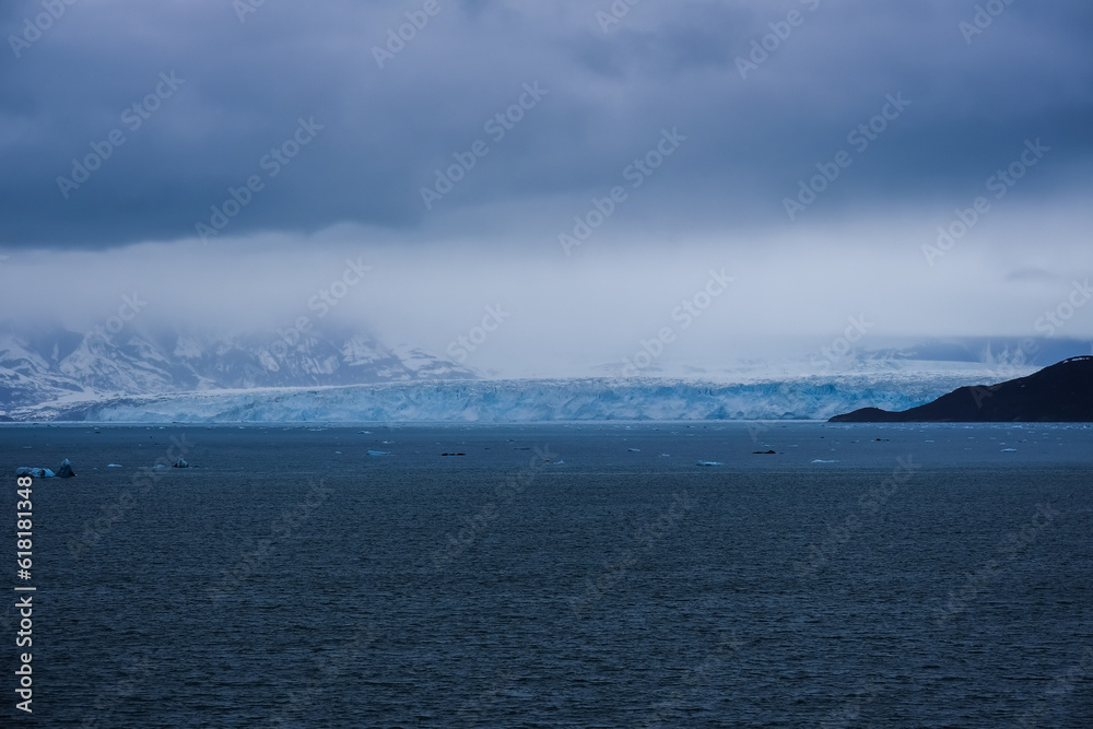 Cruise to Hubbard Glacier Bay in Alaska with floating ice bergs and drift ice floes on ocean water surface surrounded by snow cap mountains wildlife wilderness nature scenery Last Frontier adventure